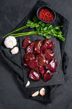 Taş tahtada çiğ hindi ciğeri. Siyah arka plan. Üst görünüm
