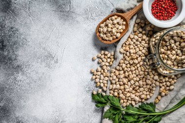 Maydanoz ve pembe biberli cam kavanozda nohut. Sağlıklı vejetaryen yemekleri. Gri arka plan. Üst Manzara. Metin için boşluk.