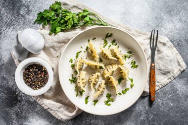 Etli hamur tatlısı, ravioli. Doldurulmuş hamur tatlısı. Gri arka plan. Üst görünüm
