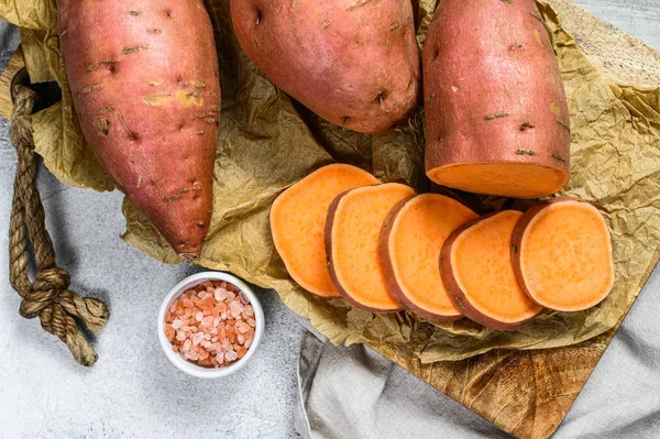 Kentang manis pada papan potong, ubi. Sayuran pertanian. Latar belakang abu abu — Stok Foto