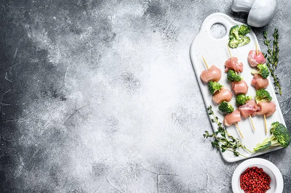 Rå kycklingkebab med broccoli. Grå bakgrund. Högst upp. Plats för text — Stockfoto