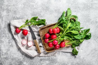 Tahta bir kasede taze kırmızı turplar. Çiftlik organik sebzeler. Gri arka plan. Üst görünüm