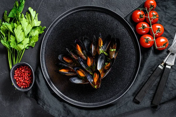 Mexilhões em molho de tomate decorado com salsa e tomate cereja. Fundo preto. Vista superior — Fotografia de Stock