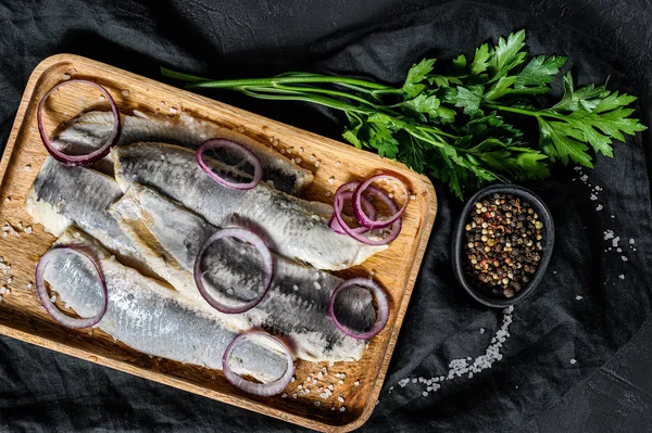 Filete de arenque marinado con pimienta, hierbas y cebolla roja. Fondo negro. Vista superior —  Fotos de Stock