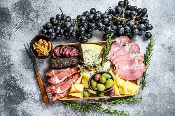 Prato antipasto com presunto, presunto, salame, queijo azul, mussarela e azeitonas. Fundo cinzento. Vista superior — Fotografia de Stock