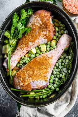 Tavuk yahnisi. Maydanozlu, bezelyeli, kerevizli ve patatesli but tarifi. Gri arka plan. Üst görünüm