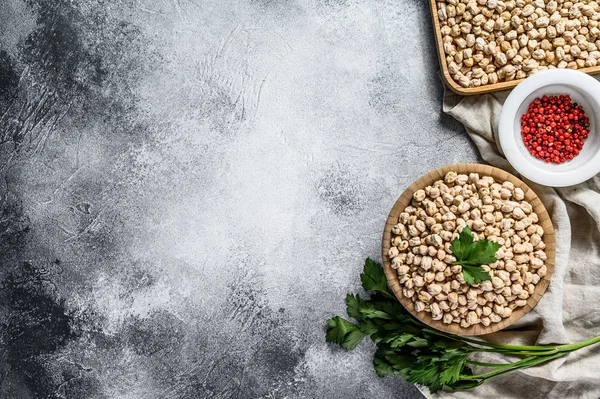 Garbanzos secos sin cocer en tazón de madera. Fondo gris. Vista superior. Espacio para texto — Foto de Stock