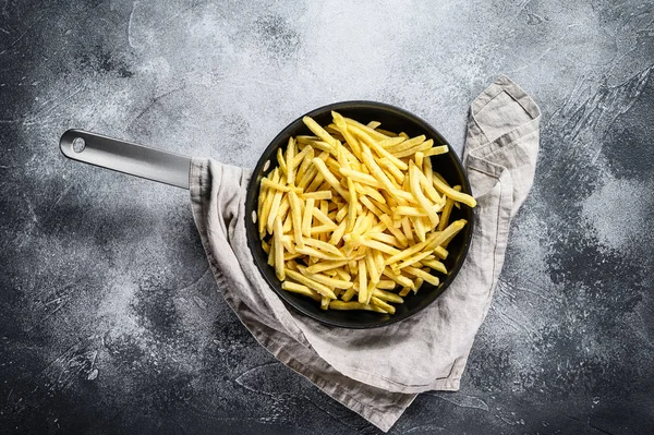Frozen French fries in a frying pan. Gray background. Top view. Space for text — Stock Photo, Image