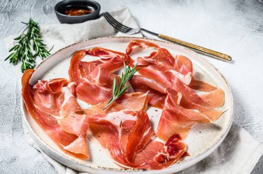 İspanyol jamonu Serrano, jambon. Antipasto tabağı. Gri arkaplan, üst görünüm.
