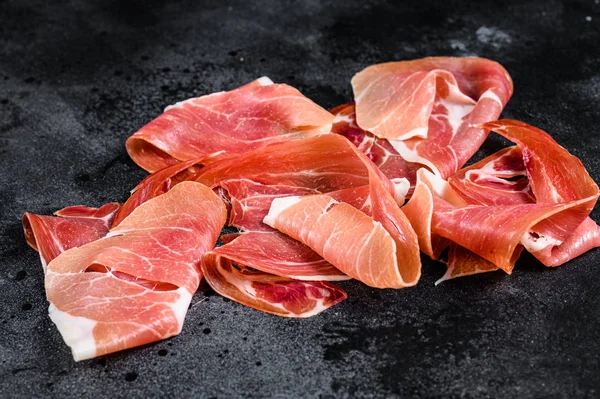 Prosciutto Crudo, İtalyan salamı, parma jambonu. Antipasto tabağı. Siyah arkaplan, üst görünüm.