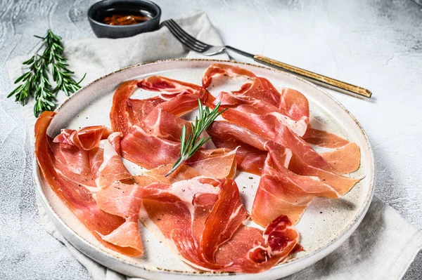 Spanyol jamon Serrano, sonkát. Pasztóellenes tányér. Szürke háttér, felülnézet. — Stock Fotó