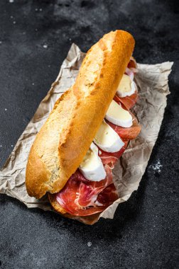 Jamon jambonlu sandviç, paleta iberica, Camembert peyniri. Siyah arkaplan, üst görünüm.