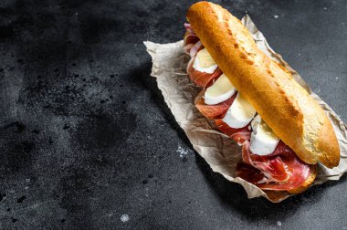 Jamon jambonlu sandviç, paleta iberica, Camembert peyniri. Siyah arkaplan, üst görünüm, metin için boşluk