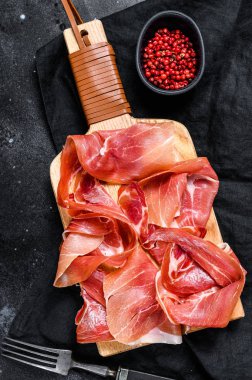 Prosciutto Crudo, İtalyan salamı, parma jambonu. Antipasto tabağı. Siyah arkaplan, üst görünüm.