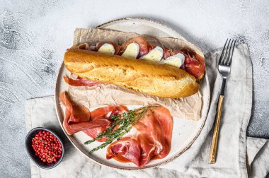 Jamon jambonlu sandviç, paleta iberica, kesim tahtasında Camembert peyniri. Gri arkaplan, üst görünüm.