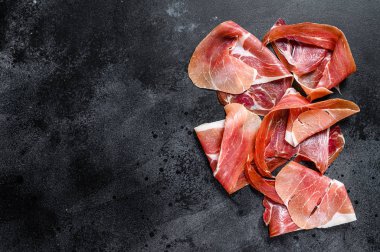 Prosciutto Crudo, İtalyan salamı, parma jambonu. Antipasto tabağı. Siyah arkaplan, üst görünüm, metin için boşluk