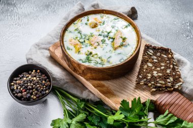Somon, alabalık, patates ve maydanozlu kremalı balık çorbası. Gri arkaplan, üst görünüm.