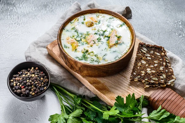 Creamy fish soup with salmon, trout, potatoes and parsley. Gray background, top view. — Stock Image Creamy fish soup with salmon, trout, potatoes and parsley. Gray background, top view. Stock Image