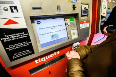 The girl buys a ticket in the underground subway, in an automatic machine. 03.01.2020 Barcelona, Spain