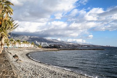 Black volcanic sand. Beach of Las Americas with views of the sea and the waves. Tenerife, Canary Islands, Spain.