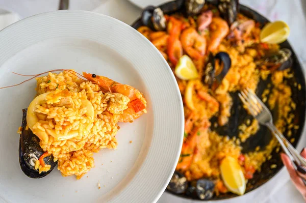Spanish paella with seafood served in a pan. Fresh Shrimp, Scampi, mussels, squid, octopus and scallops. Top view. Selective focus. Restaurant — 스톡 사진