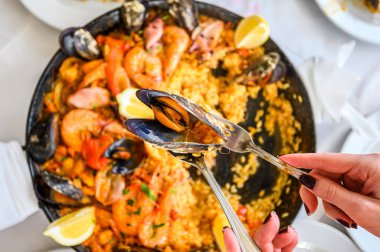 Tavada servis edilen deniz mahsullü İspanyol paellası. Taze karides, Scampi, midye, kalamar, ahtapot ve deniz tarağı. Üst Manzara. Seçici odaklanma. Restoran