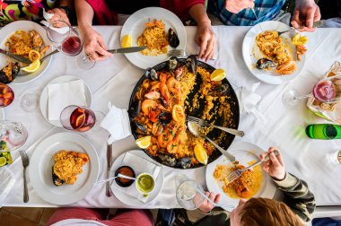 Restorandaki, tavada servis edilen İspanyol paella ve deniz ürünleri masası. Taze karides, Scampi, midye, kalamar, ahtapot ve deniz tarağı. Üst Manzara. Restoran
