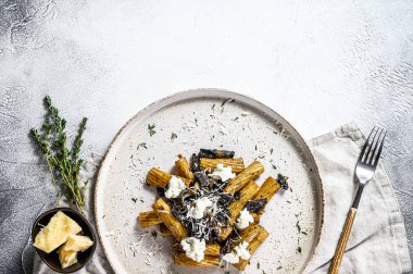 Siyah trüf mantarlı makarna ve beyaz mantarlı Boletus edulis. Gri arka plan. Üst Manzara. Metin için boşluk