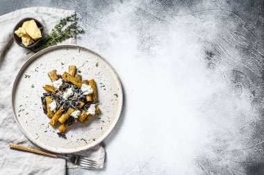 Siyah mantarlı makarna, beyaz mantar, krema sosu ve ricotta peyniri. Gri arka plan. Üst Manzara. Metin için boşluk