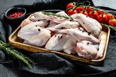 Ahşap bir kasede çiğ hindi kanadı, biberiye ve pembe biber malzemeleri. Çiftlik organik eti. Üst Manzara. Siyah arkaplan