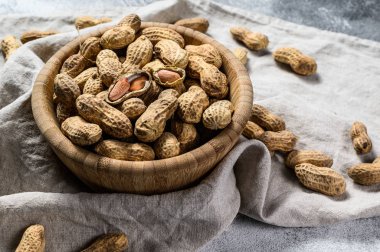 Kabuklu fıstıklar. Organik çiğ yer fıstığı. Gri arka plan. Üst Manzara. Metin için boşluk