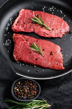 Tavada çiğ sığır filetosu. Et eti. Siyah arka plan. Üst görünüm