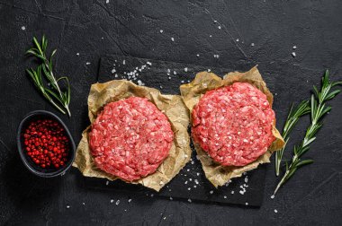 Ev yapımı çiğ kıymalı biftek köftesi. Çiftlik organik eti. Siyah arka plan. Üst görünüm