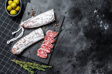 Fuet Salam dilimleri ve Rosemary. Geleneksel İspanyol sosisi. Siyah arka plan. Üst Manzara. Metin için boşluk