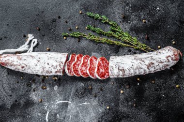Fuet Salam dilimleri ve Rosemary. Geleneksel İspanyol sosisi. Siyah arka plan. Üst görünüm