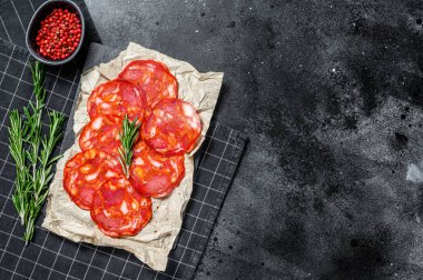 Dilimlenmiş sucuklu salam. İspanyol geleneksel sucuk sosisi. Siyah arka plan. Üst Manzara. Metin için boşluk