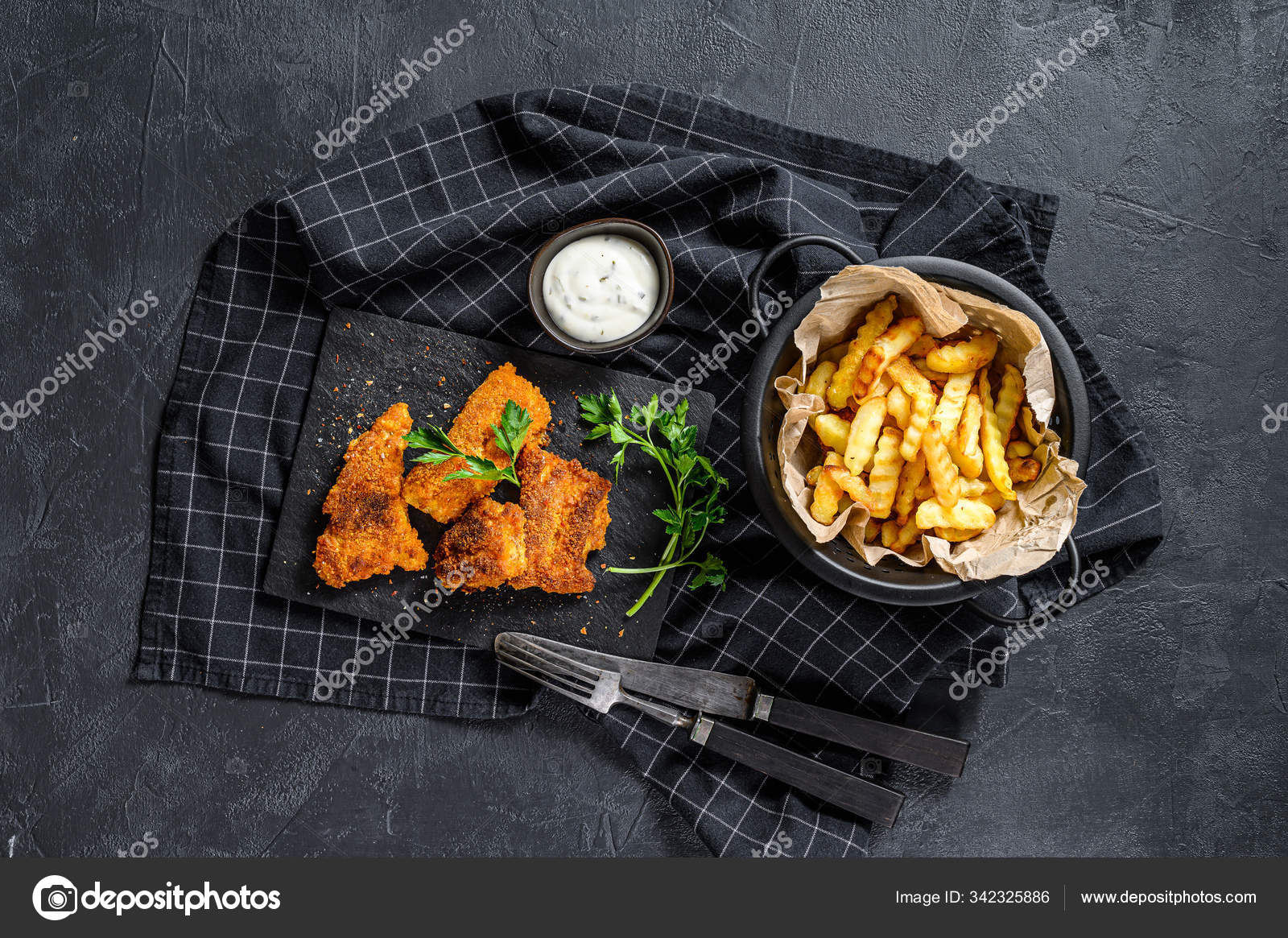 Fish and chips, French fries and cod fillet fried in breadcrumbs. Black