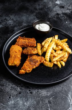 Balık ve patates kızartması, geleneksel İngiliz yemekleri. Siyah arka plan. Üst görünüm