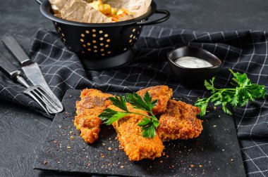 Tavada kızarmış balık fileto ve patates kızartması. Siyah arka plan. Üst görünüm