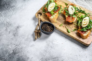 Keçi peyniri, roka ve armut reçeli baget ekmekli kanepeler. Gri arka plan. Üst Manzara. Boşluğu kopyala