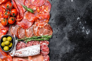 İspanyol soğuk et çeşitleri. Chorizo, fuet, LOMO, jamon Iberico, zeytin. Siyah arka plan. Üst Manzara. Boşluğu kopyala