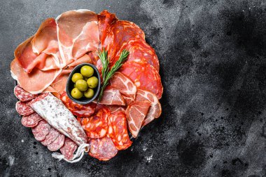 Geleneksel İspanyol mezelerinden yapılmış bir tabak et. Chorizo, Jamon Serrano, Lomo ve Fuet. Siyah arka plan. Üst Manzara. Boşluğu kopyala