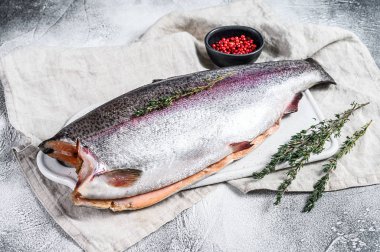 Taze gökkuşağı balığı. Tuz ve kekik ile marine edilmiş. Gri arka plan. Üst görünüm