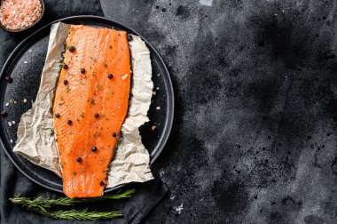 Taze deniz alabalığı fileto, tuz, bitki ve baharatlı. Siyah arka plan. Üst Manzara. Boşluğu kopyala