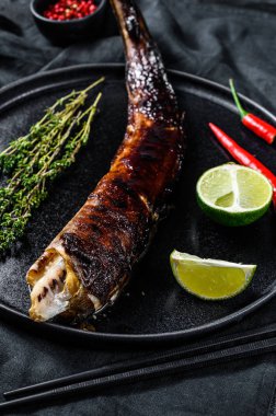 Izgara Kral Klip, teriyaki soslu congrio. Siyah arka plan. Üst görünüm