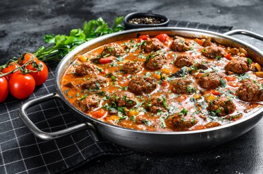 Domates soslu domuz köftesi ve tavada sebze. Siyah arka plan. Üst görünüm