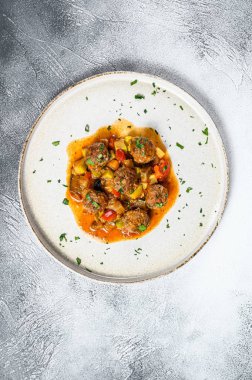 Domates soslu kıymadan yapılmış lezzetli köfteler, eski metal tavada servis ediliyor. Gri arka plan. Üst Manzara. Metin için boşluk