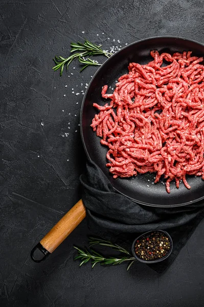 Raw minced pork in a frying pan. Black background. Top view. Space for text — Stock Photo, Image