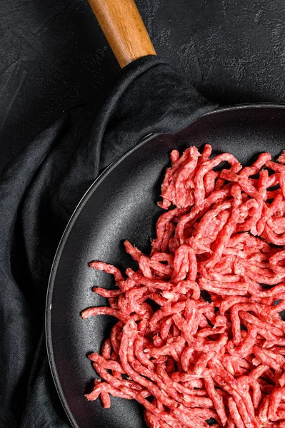 Manzo di marmo tritato crudo in padella. Fondo nero. Vista dall'alto — Foto Stock