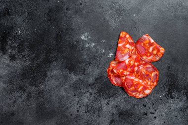 Dilimlenmiş sucuklu salam. İspanyol geleneksel sucuk sosisi. Siyah arka plan. Üst Manzara. Metin için boşluk